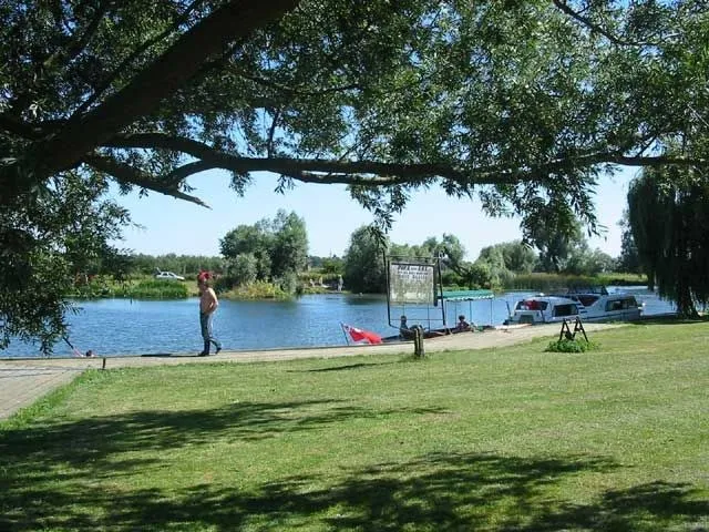 View along the marina and river at the Pike & Eel, moored boats and the pub sign in the distance